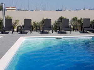 - une piscine avec des chaises à côté de la plage dans l'établissement Apartment D&D, à Bibinje