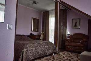 a bedroom with a bed and a chair and a window at Aivengo Hotel in Rivne