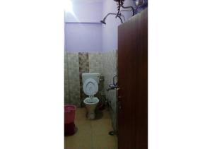 a bathroom with a white toilet in a room at Ishwari Narayani Hotel in Joshīmath