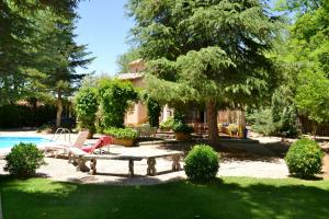 a backyard with a picnic table and a pool at Chalet rural en La Mancha con jardin y piscina privados in Tomelloso