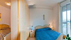 ビビオーネにあるAuriga del Soleのベッドルーム1室(青い毛布、窓付)