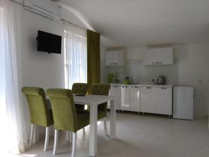 a kitchen with a table and chairs in a room at Guest House in Mukacheve