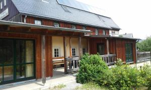 een groot houten huis met een veranda en ramen bij Ferienhaus "Zur Ottendorfer Hütte" in Ottendorf