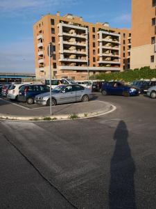 l'ombra di una persona che si trova di fronte a un parcheggio di Perugino Apartments a Fiumicino