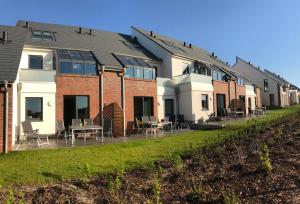 een rij huizen met tafels en stoelen op een gazon bij Tor zum Meer in Helgoland