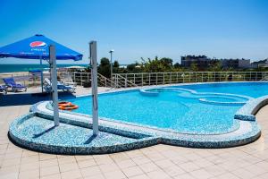 una gran piscina con sombrilla y sillas en Gold Bugaz Black Sea Hotel Group, en Grybivka