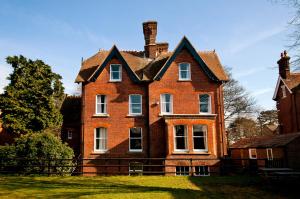 una gran casa de ladrillo rojo con techo en YHA Canterbury, en Canterbury