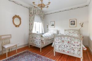 1 Schlafzimmer mit 2 Betten und einem Spiegel in der Unterkunft Storebro Herrgård in Vimmerby
