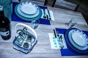 a table with blue and white plates and a bottle of wine at Piana delle Galee in Scilla