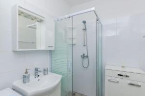 a white bathroom with a shower and a sink at Guest House Nenada in Dubrovnik +12 photos
