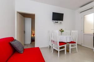 a living room with a red couch and a table at Guest House Nenada in Dubrovnik