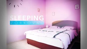 a bedroom with a bed with a sign that reads sleeping zone at Studio apartman Zorkovac in Ozalj