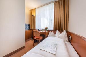 Postel nebo postele na pokoji v ubytování Parkhotel Stadtallendorf
