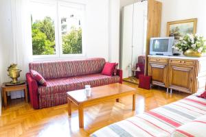 a living room with two couches and a tv at Chalandri Home Away in Athens