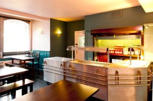 a restaurant kitchen with tables and tables in a room at YHA Canterbury in Canterbury