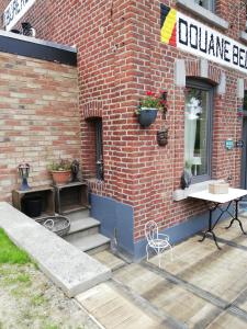 a brick building with a table and a sign on it at La petite douane in Massembre