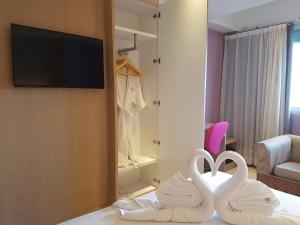two white swans sitting on a bed in a hotel room at Kavin Buri Green Hotel in Udon Thani