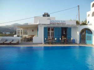 un hotel con piscina frente a un edificio en Golden Sun en Ios Chora