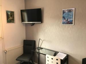 Cette chambre dispose d'une table en verre et d'une télévision murale. dans l'établissement Hotel de la Gare, à Saint-Mihiel