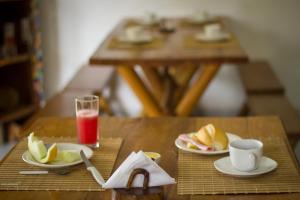 una mesa con dos platos de comida y un vaso de zumo en Pousada Umbudendê, en Barra Grande