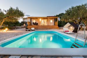 a swimming pool in front of a house at Authentic Camping Dalmatia in Pirovac