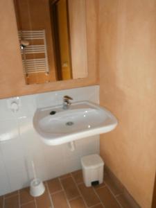 een badkamer met een witte wastafel en een spiegel bij La cascina di Anna in Beverino