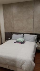 un letto bianco con due cuscini sopra di Tini Icity Guesthouse a Shah Alam