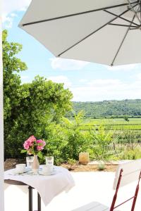 a table with a white umbrella and flowers on it at Vila Flora in Sečovlje