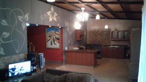 a living room with a couch and a tv at Casa Grande Retiro para grupos in Cerro Azul