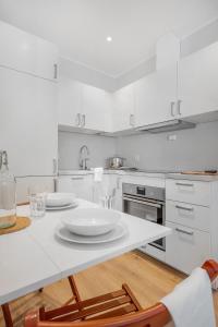 a white kitchen with a table and two chairs at NG Apartments in Bergen