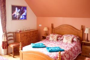 una camera da letto con letto in legno e cuscini blu di La Nesliere Chambres d'Hôtes Bio a Saint-Symphorien-des-Monts