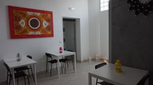 two tables and chairs in a room with a painting on the wall at Marselo B&B in Bari