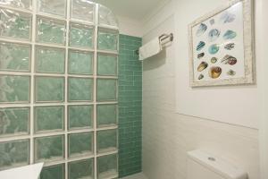 a bathroom with a shower with green tiled walls at Casas da Avó II in Santa Cruz +7 photos