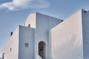 a white church with a blue sky in the background at Istoria, a Member of Design Hotels in Perivolos