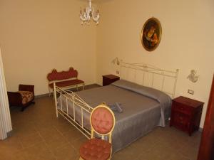 シラクーサにあるLa casa di Benedettaのベッドルーム1室(ベッド1台、椅子、鏡付)