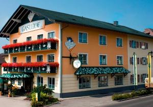 un grande edificio arancione con fiori alle finestre di Hotel Blumauer a Rainbach im Mühlkreis