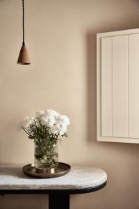 a vase of white flowers on a table in a kitchen at Istoria, a Member of Design Hotels in Perivolos