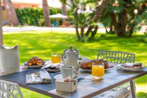 a table with breakfast foods and orange juice on it at Marina Garden Hotel in Marciana Marina