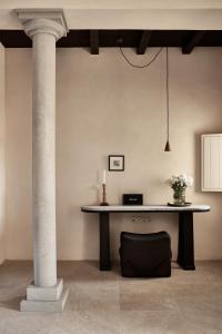 a table in a room with a pillar and a candle at Istoria, a Member of Design Hotels in Perivolos