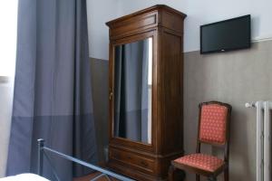 um armário de madeira e uma cadeira num quarto em Loggia Fiorentina em Florença