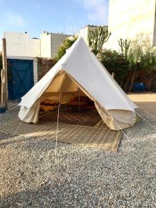 une grande tente blanche assise au sol dans l'établissement Gite Le Nomade, à Mirleft