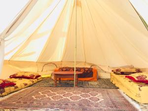 een tent met twee bedden en een tafel erin bij Gite Le Nomade in Mirleft