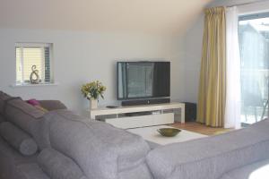 a living room with a couch and a tv at 9 Sandpiper Cottages in Newquay