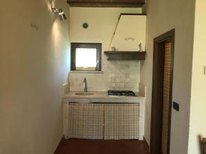 a small kitchen with a sink and a window at Tenuta La Tabaccaia in La Pesta