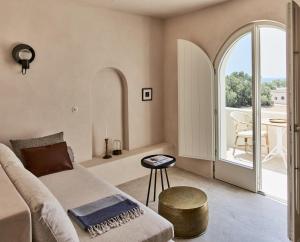 a living room with a couch and a table at Istoria, a Member of Design Hotels in Perivolos