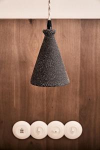 a black chandelier hanging from a ceiling with four buttons at Istoria, a Member of Design Hotels in Perivolos
