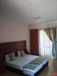 a bedroom with a large bed and a window at Maya Bay in Kallithea Halkidikis