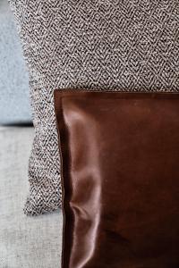 a brown leather wallet sitting next to a pillow at Istoria, a Member of Design Hotels in Perivolos