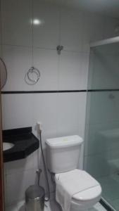 a white toilet sitting in a bathroom next to a sink at Itaparica Praia Hotel in Vila Velha