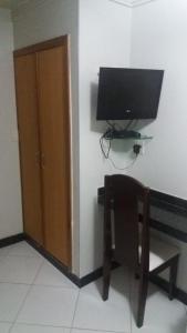 a room with a television and a chair at Itaparica Praia Hotel in Vila Velha